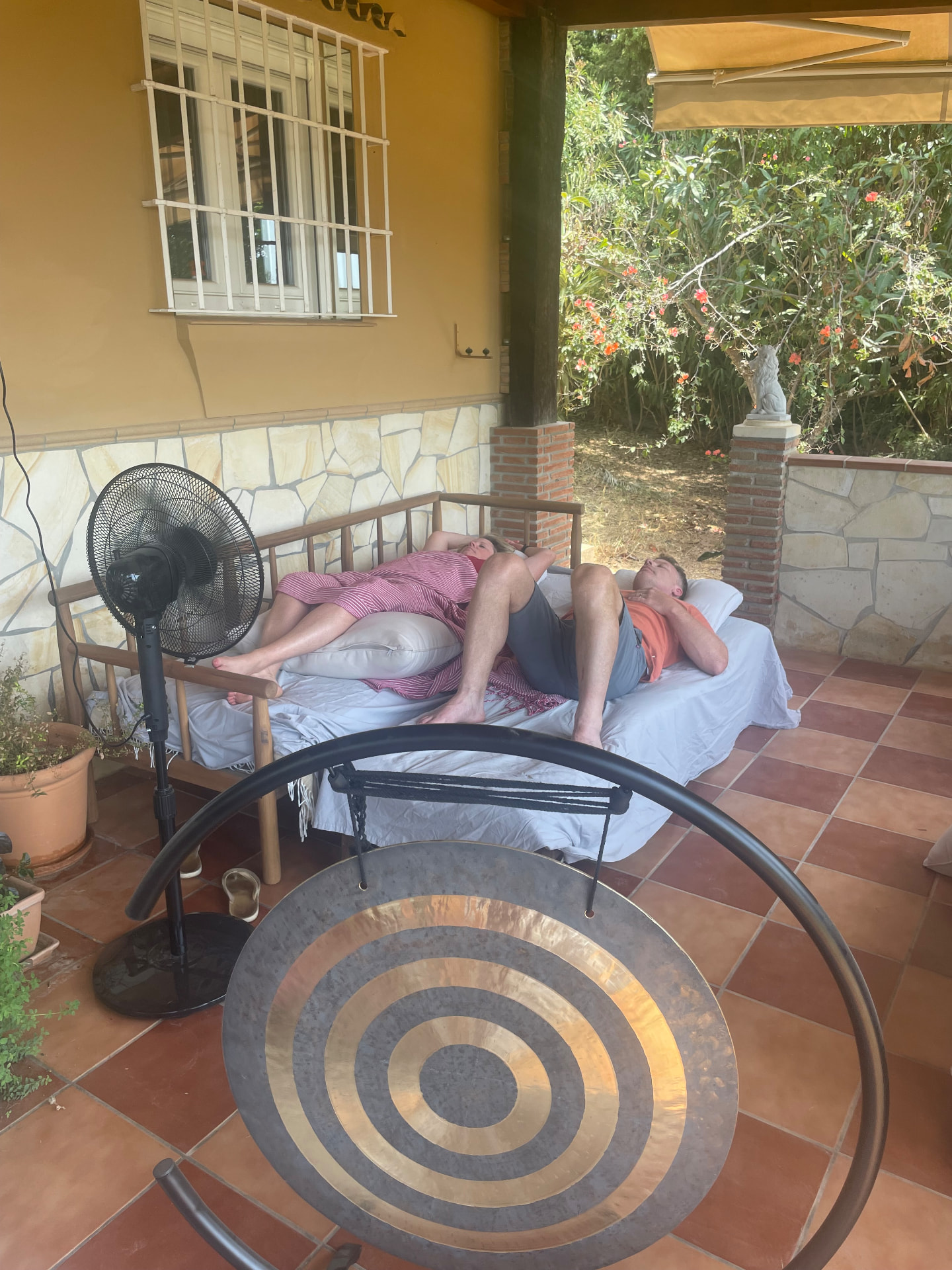 A couple resting side by side during a sound healing session on the terrace