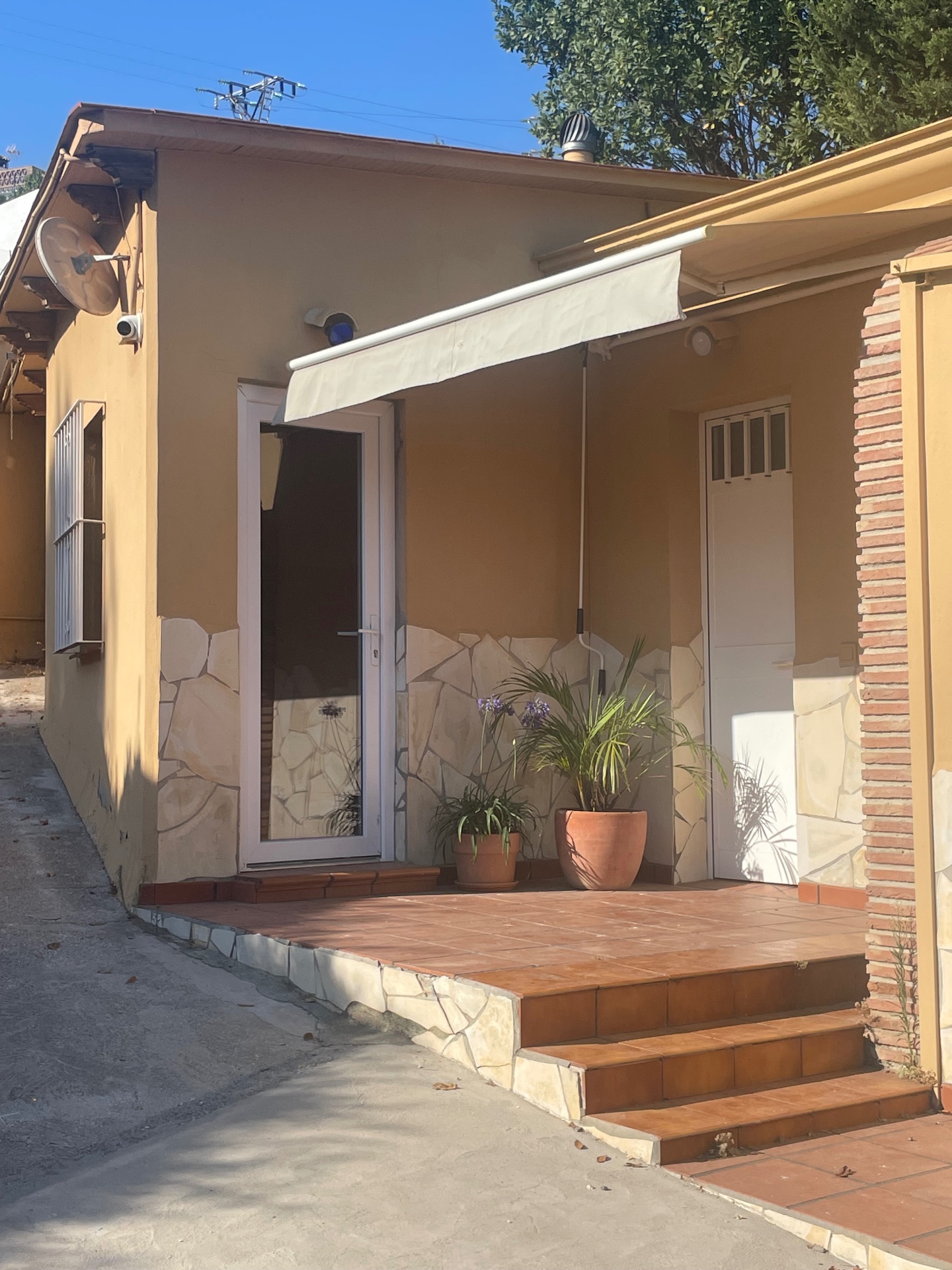 Studio entrance with awning and tiled porch